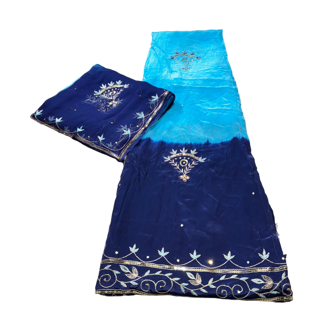 Blue and turquoise embroidered fabric on a light gray surface