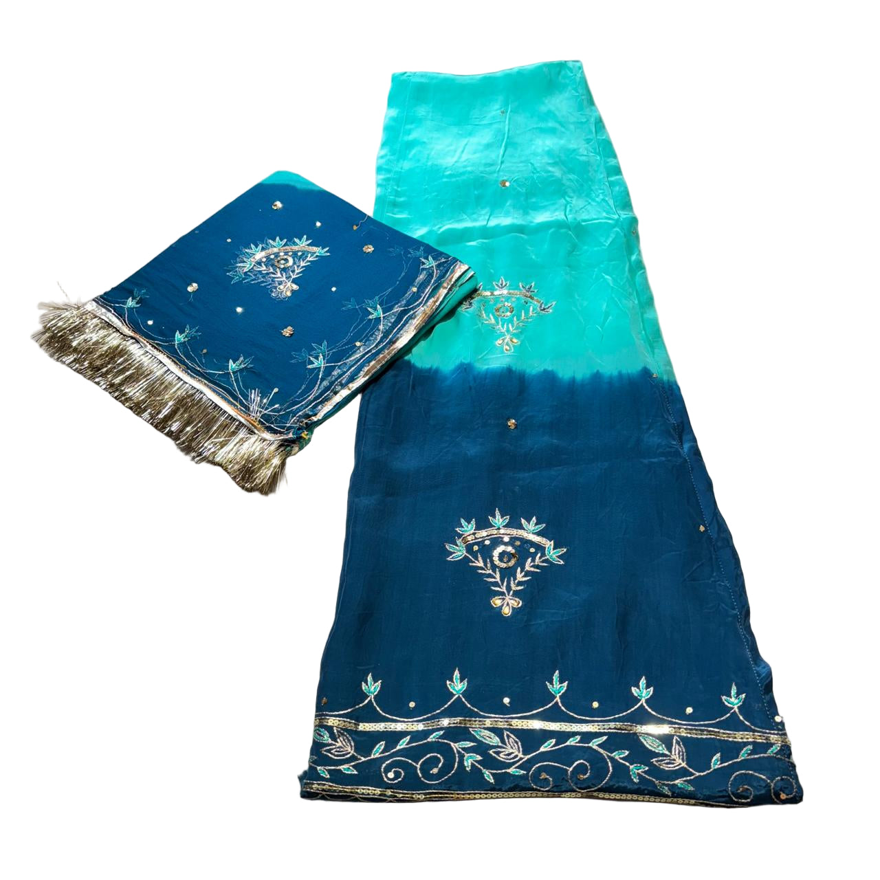 Blue and green fabric with embroidery on a light gray surface