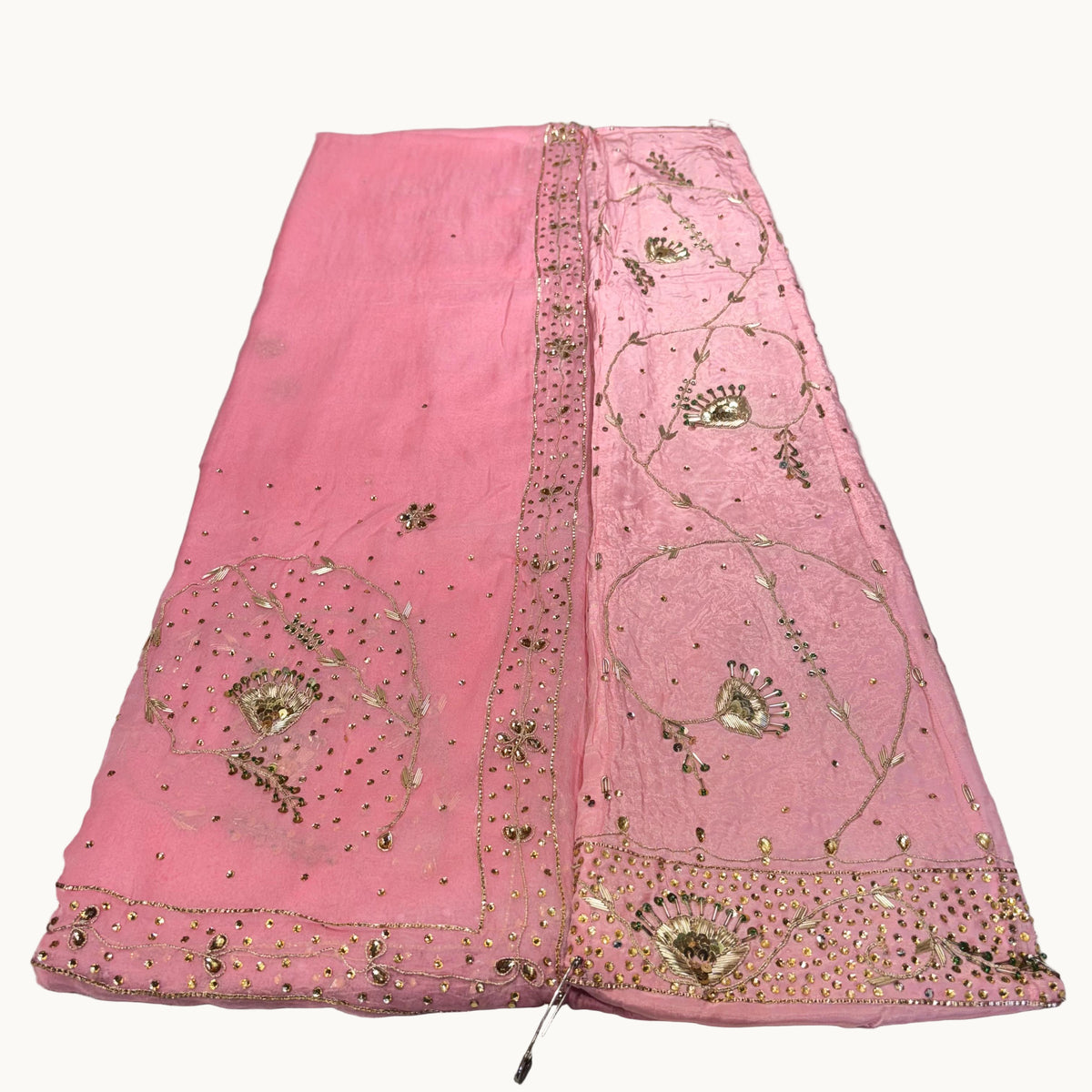 Pink embroidered fabric on a light gray background
