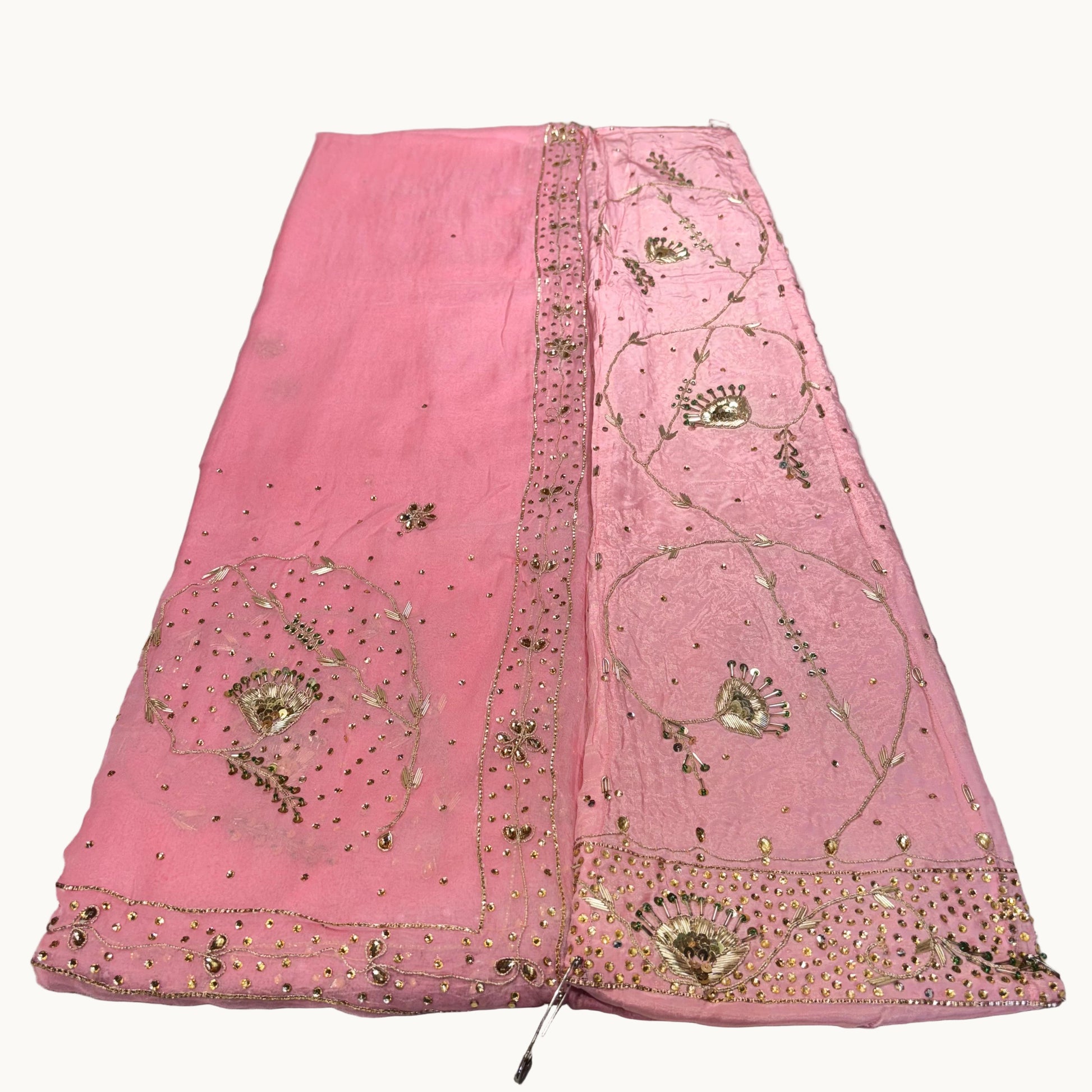 Pink embroidered fabric on a light gray background