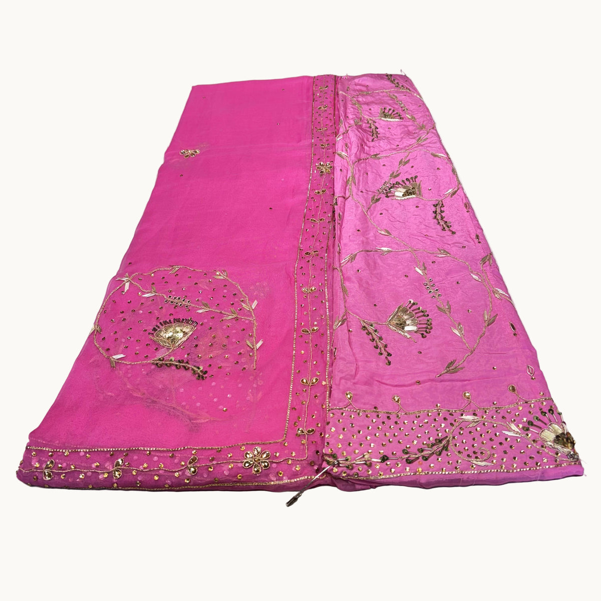 Pink embroidered fabric on a light gray surface
