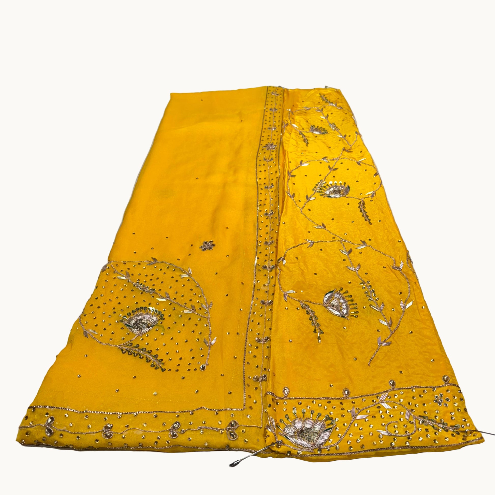 Yellow embroidered fabric on a white surface