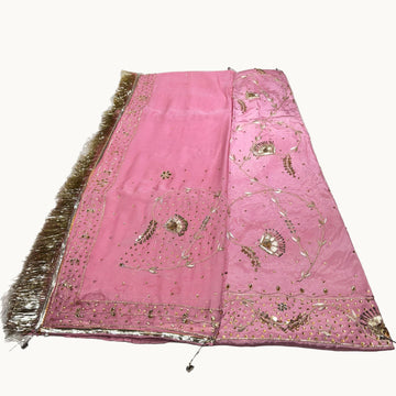 Pink embroidered fabric with gold details on a white background