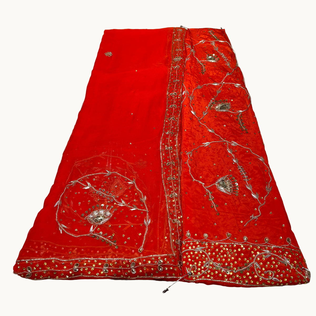 Red fabric with silver embroidery on a white background