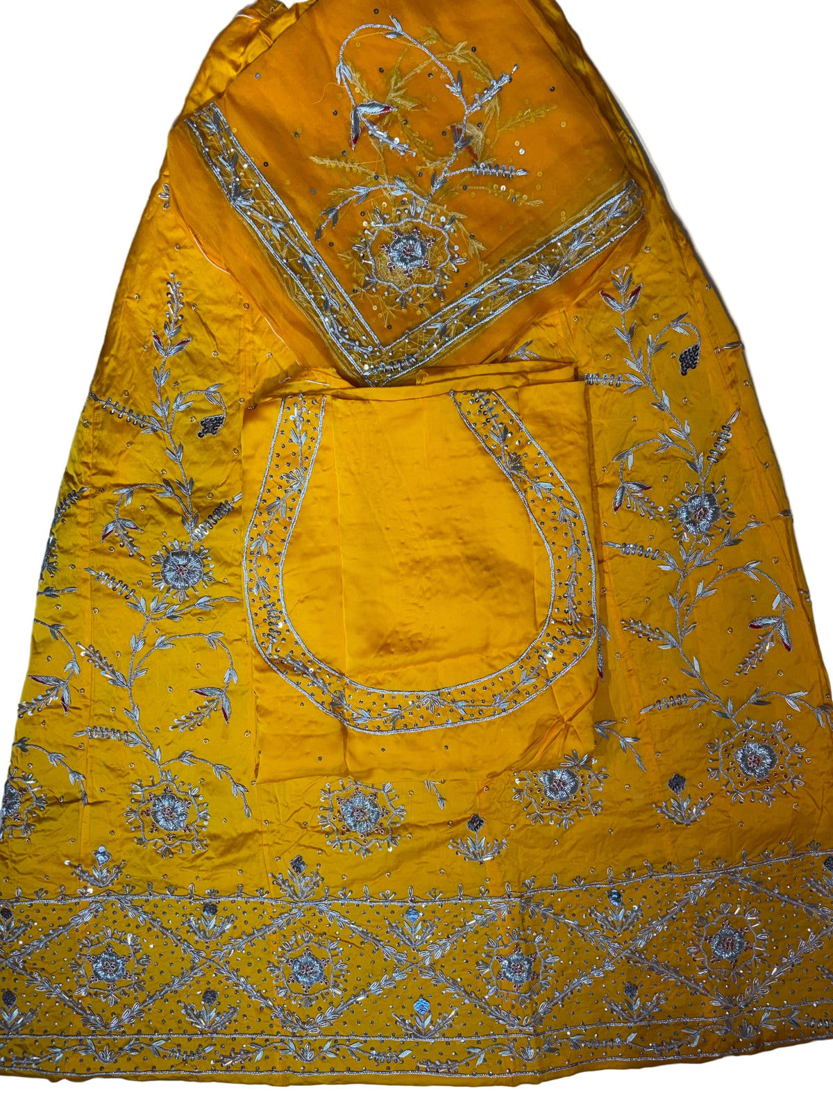 Yellow embroidered fabric with intricate patterns on a plain background