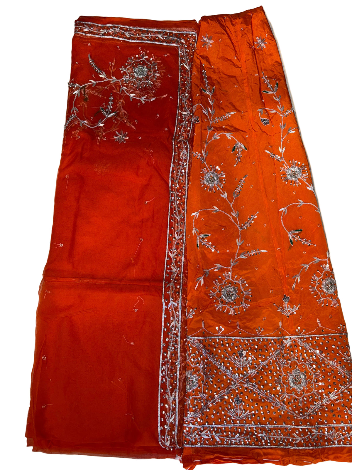 Red fabric with intricate white embroidery on a light background