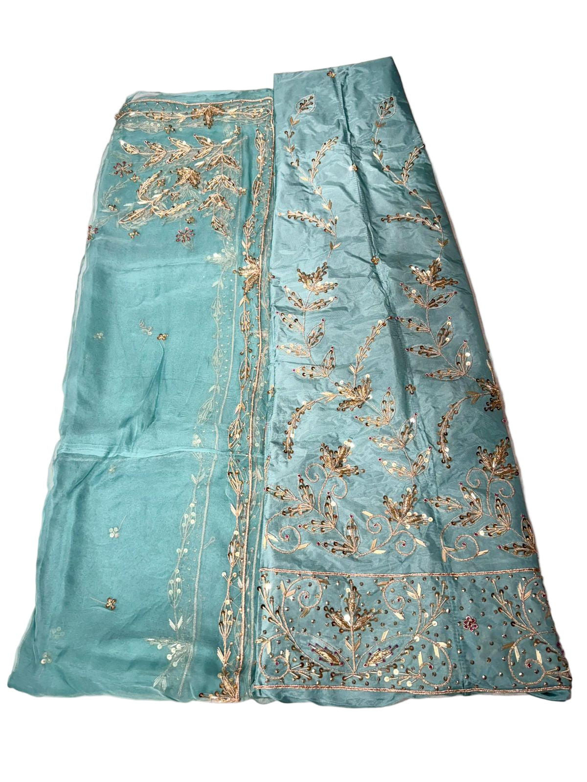 Teal fabric with gold embroidery on a pink background