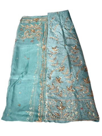 Teal fabric with gold embroidery on a pink background