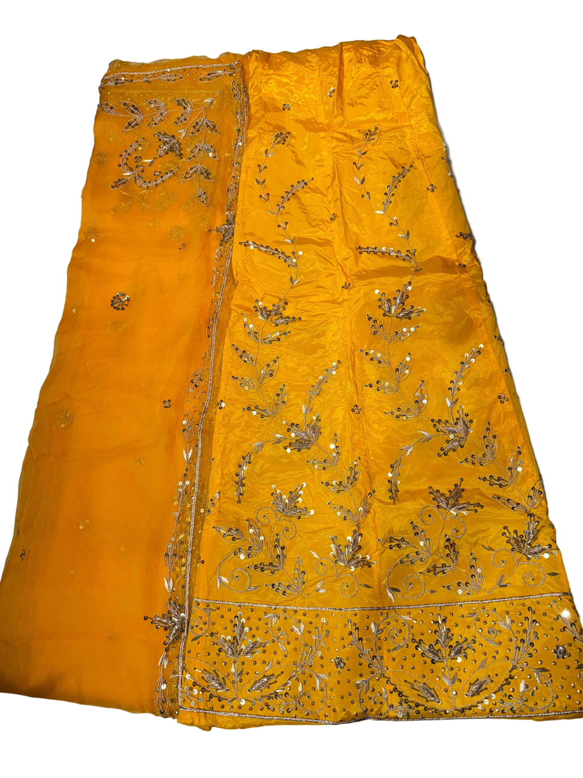 Yellow fabric with gold embroidery on a white surface