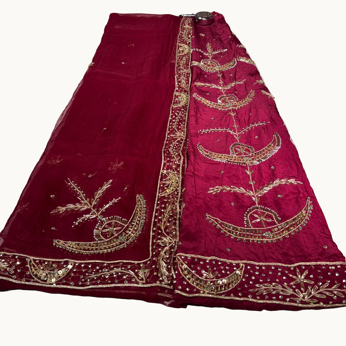 Red embroidered saree on a white surface