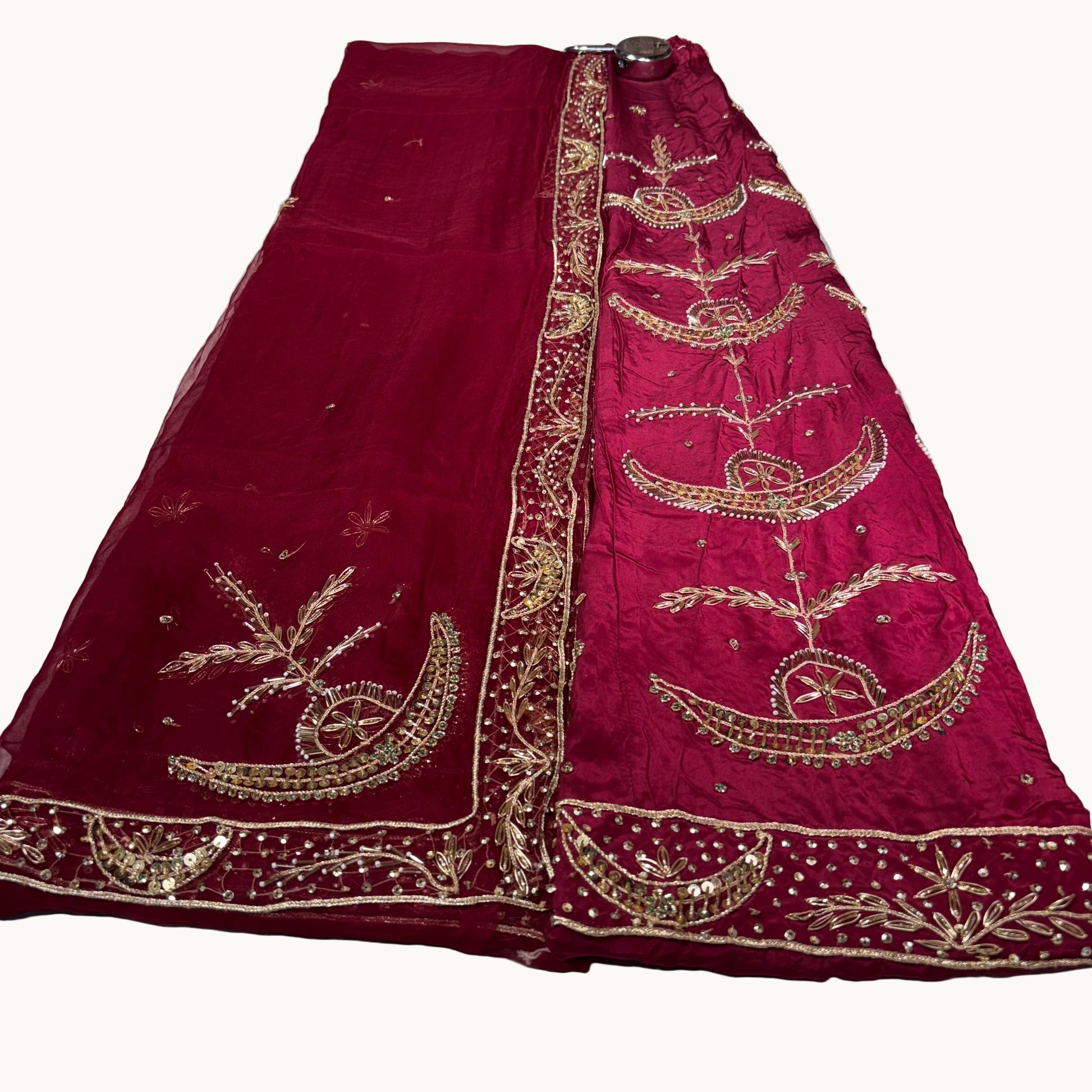 Red embroidered saree on a white surface