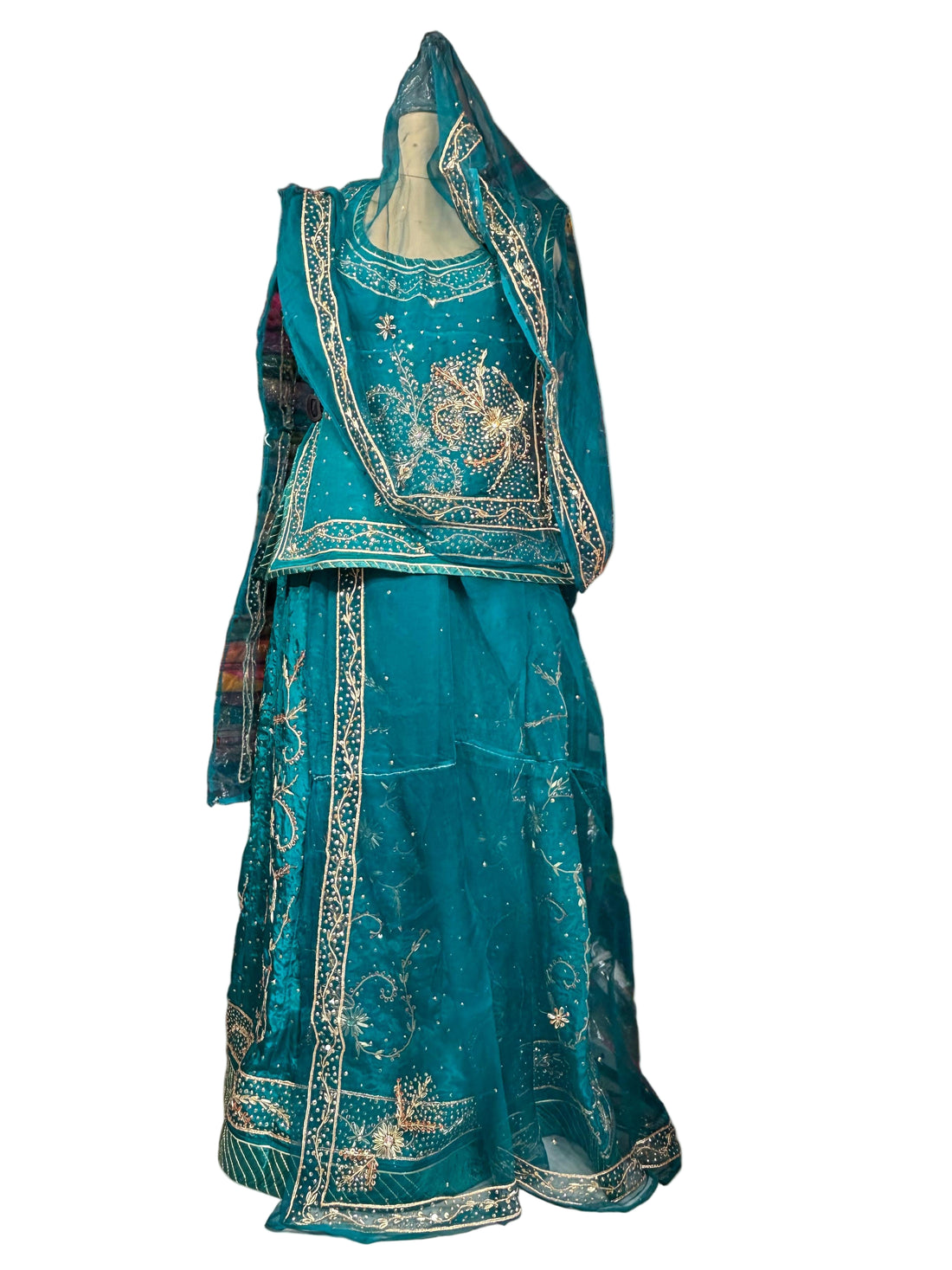 Teal embroidered traditional outfit on a mannequin in a fabric store.
