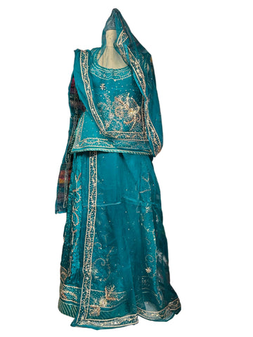 Teal embroidered traditional outfit on a mannequin in a fabric store.