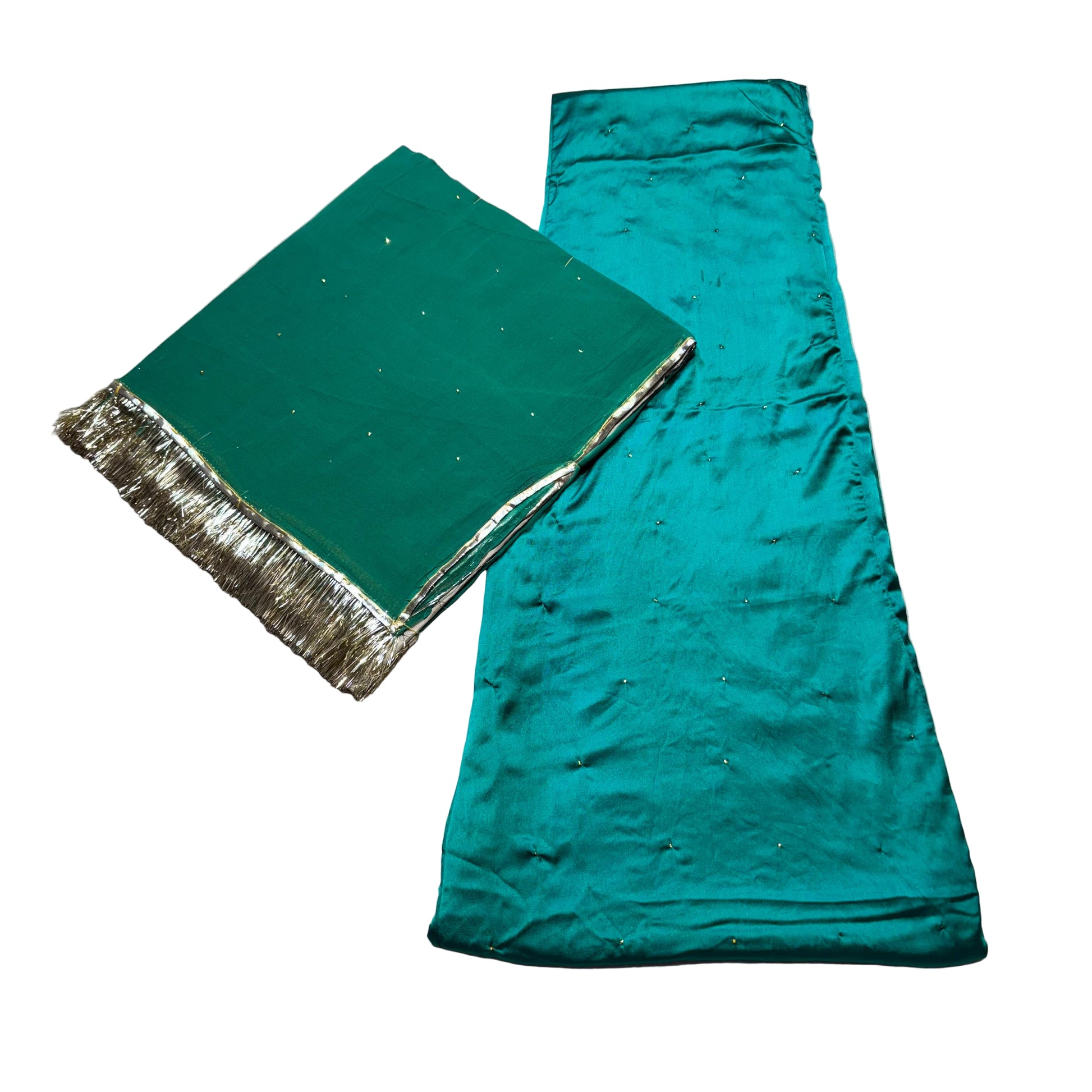 Two green fabrics with gold trim on a textured beige surface